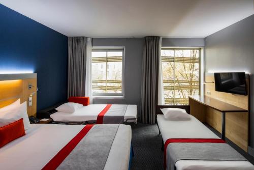 a hotel room with two beds and a tv at Holiday Inn Express Paris-Canal De La Villette by IHG in Paris