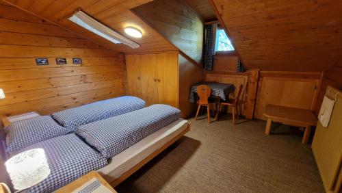 サースフェーにあるChalet La Sapinièreの木造キャビン内のベッド1台が備わるベッドルーム1室を利用します。