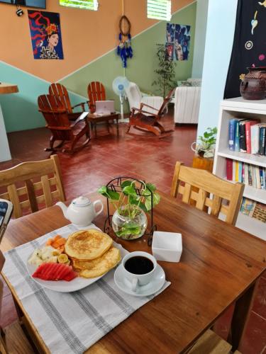 a table with a plate of breakfast food on it at Hostal tortuga viajera in Moyogalpa