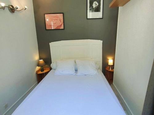 a bedroom with a white bed with two night stands at Appartement Cauterets, 3 pièces, 4 personnes - FR-1-234-139 in Cauterets