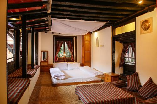 Newa Chen Historic House UNESCO في باتان: غرفة نوم فيها سرير وسريرين