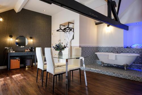 a bathroom with a glass table and a tub at Best Western Lichfield City Centre The George Hotel in Lichfield