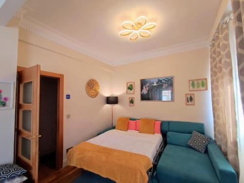 a bedroom with a bed and a blue couch at San Mamés Stadium corner in Bilbao