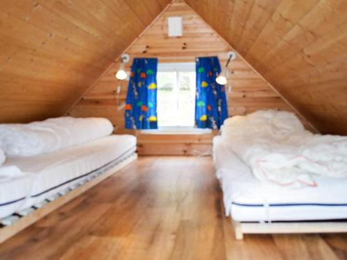 a attic room with two beds and a window at 4 person holiday home in MÅLØY-By Traum in Måløy