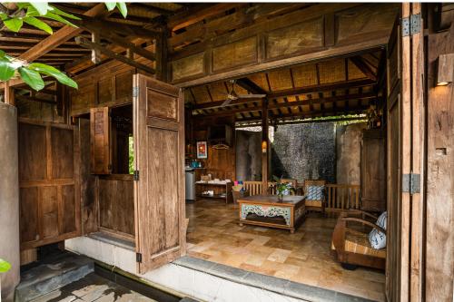 an open door of a wooden house with a table at Yabbiekayu in Yogyakarta
