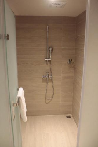 a shower with a shower head in a bathroom at Chiayi Maison de Chine Hotel in Chiayi City