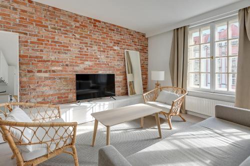 sala de estar con pared de ladrillo en Comfort Apartments Długi Targ, en Gdansk