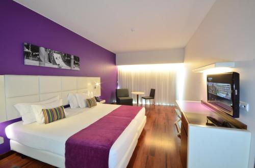 Habitación de hotel con cama grande y TV en Aquashow Park Hotel en Quarteira
