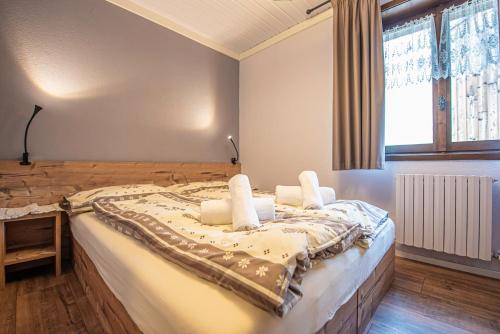 a bedroom with a large bed with white pillows at Chalet Colombo MyholidayLivigno in Livigno