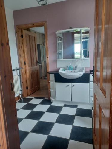 uma casa de banho com piso em xadrez preto e branco em Loughview Retreat in the Mournes em Newcastle