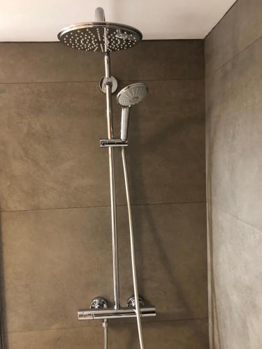 une douche avec pommeau de douche dans une salle de bain dans l'établissement Chalet de l'Orceyrette, idéal pour un couple ou famille avec 2 enfants, à Briançon