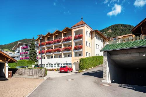 a building with a red car parked in front of it at Residence Diana Apartment 301 in Terento