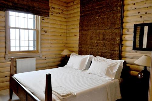 ein Schlafzimmer mit einem Bett in einem Blockhaus in der Unterkunft Chalet de Charme, Cedars, Lebanon, Terrace Floor in Al Arz