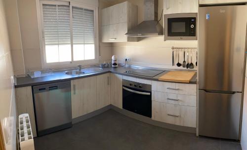 una cucina con piano cottura, lavandino e frigorifero di Alma Apartamento a Daimuz Bajo