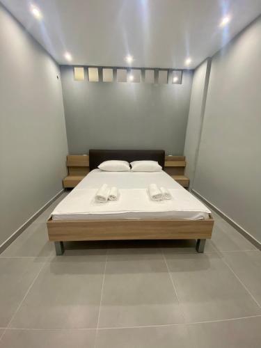 a bedroom with a bed with two towels on it at Central Square Family Apartment in Nea Kalikratia