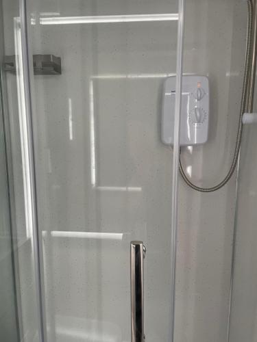 eine Glastür mit einem Griff im Bad in der Unterkunft Private en-suite garden room in Countess Wear