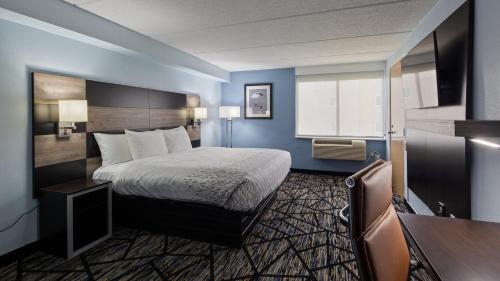 ジャクソンビルにあるClarion Pointe Jacksonville near Camp Lejeuneのベッドとデスクが備わるホテルルームです。