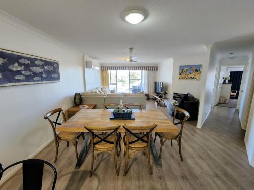 a dining room and living room with a table and chairs at Fairways Golf & Beach Retreat Bribie Island in Woorim