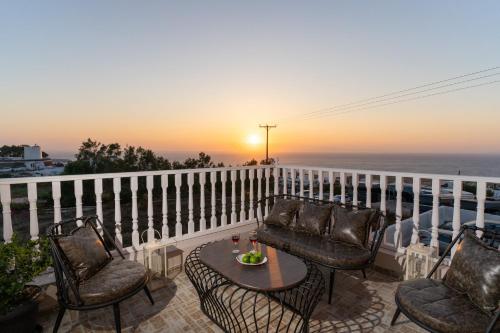a patio with chairs and a table on a balcony at Amarie House with Sea View & Sunset View in Oia