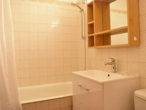 uma casa de banho com um lavatório e uma banheira em Appartement Méribel, 1 pièce, 4 personnes - FR-1-180-18 em Méribel