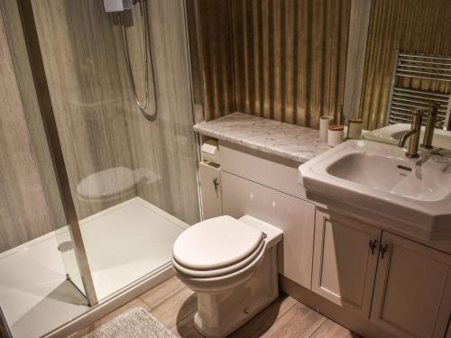 a bathroom with a toilet and a sink at The Potting Shed in Huntingdon