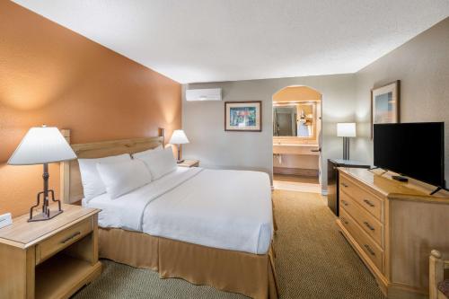 a bedroom with a bed and a flat screen tv at Pearl on the Concho SureStay Collection by Best Western in San Angelo