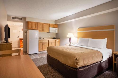 um quarto de hotel com uma cama e uma cozinha em Suburban Studios I-80 Grand Island em Doniphan