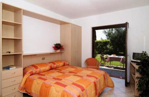 a bedroom with a bed and a balcony with a table at Residence San Luigi in Limone sul Garda