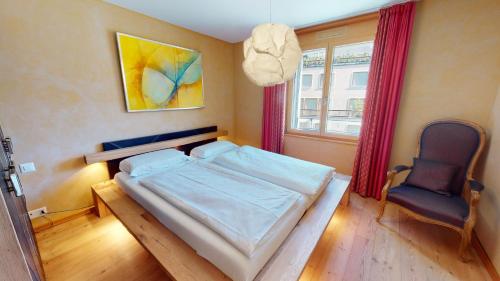 a bedroom with a bed and a chair in it at Chalcherin Duplex in Celerina