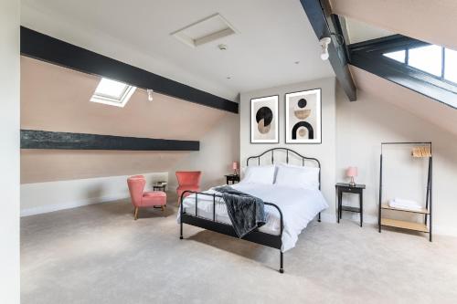 a bedroom with a bed and two orange chairs at Stunning Skipton House by Yorksha Property in Skipton