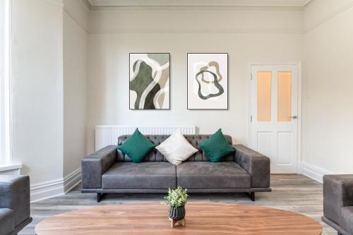 uma sala de estar com um sofá castanho com almofadas verdes em Stunning Skipton House by Yorksha Property em Skipton