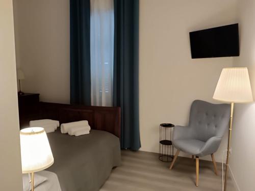 1 dormitorio con 1 cama, 1 silla y TV en b & b ultimo miglio en Treviso