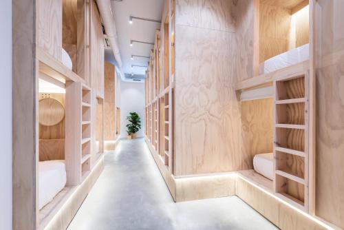 un couloir dans un bâtiment avec des étagères en bois dans l'établissement Colo Colo Hostel - Single Private Beds, à Saint-Sébastien