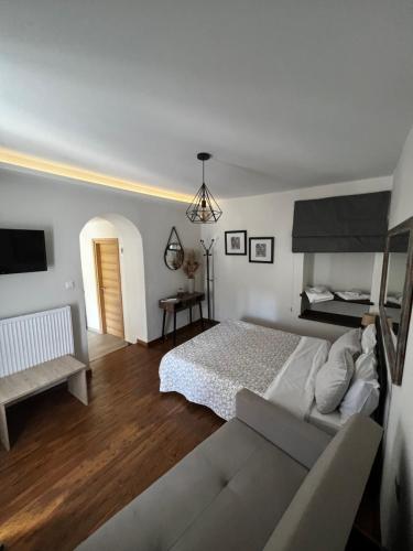 biała sypialnia z łóżkiem i kanapą w obiekcie Alkistis House w mieście Wolos