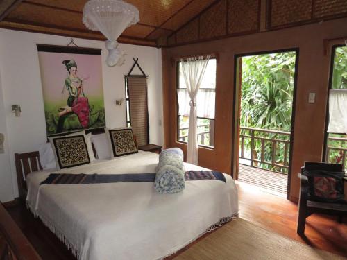 1 dormitorio con 2 camas en una habitación con ventanas en Little Eden Guesthouse, en Pang Mapha
