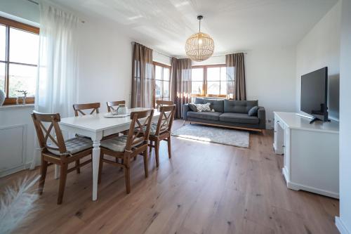 a living room with a table and chairs and a couch at Ferienwohnung "Wie dahoam" in Chieming