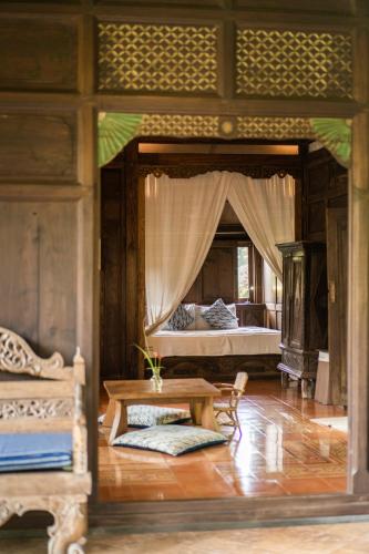 a bedroom with a bed and a table in it at Yabbiekayu in Yogyakarta