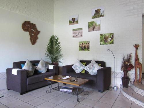 a living room with two couches and a coffee table at Manzini Chalet No 34 in St Lucia