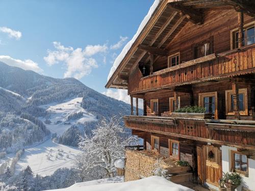 a wooden house with a view of a mountain at Haus Daniela in Wildschönau