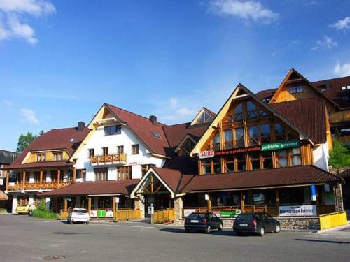 a large building with cars parked in front of it at Dolní Náměstí in Rokytnice nad Jizerou
