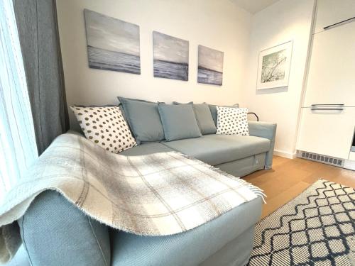 a living room with a couch with a blanket at Jauna Teika Cosy 1bdr apartment, self check-in in Rīga