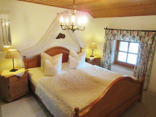 a bedroom with a large bed with a canopy at Plattenberger Hof in Waging am See