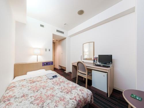 札幌市にあるHotel Tetora Spirit Sapporoのベッドとデスクが備わるホテルルームです。