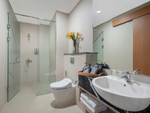 uma casa de banho com um lavatório, um WC e um chuveiro em The Reiz Suites, ARTOTEL Curated em Medan