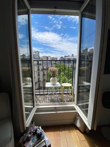 a view of a balcony with a table and vases at Lumineux, Parc Monceau, Champs Elysées, Sacré Coeur in Paris