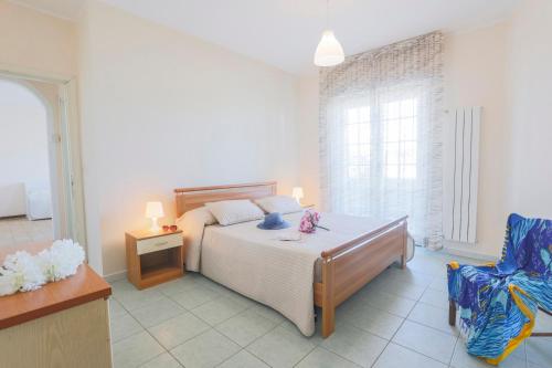 a bedroom with a bed and a blue chair at Green Marine B09 Silvi Vacanza in Silvi Marina