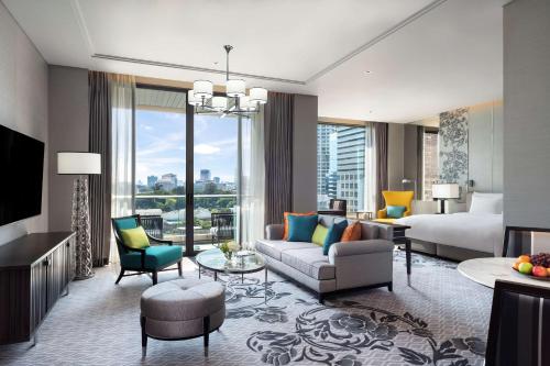 a hotel room with a king bed and a living room at Sindhorn Kempinski Hotel Bangkok - SHA Extra Plus Certified in Bangkok