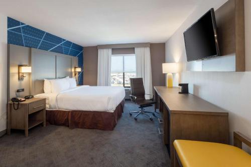 a hotel room with a large bed and a television at Comfort Inn & Suites Buffalo Airport in Buffalo