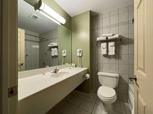 y baño con lavabo, aseo y espejo. en The Grand Tappattoo Resort, Ascend Hotel Collection en Otter Lake