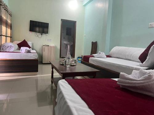 a hotel room with two beds and a table at Nayathali Hotel & Lodge Pvt. Ltd in Kawasoti